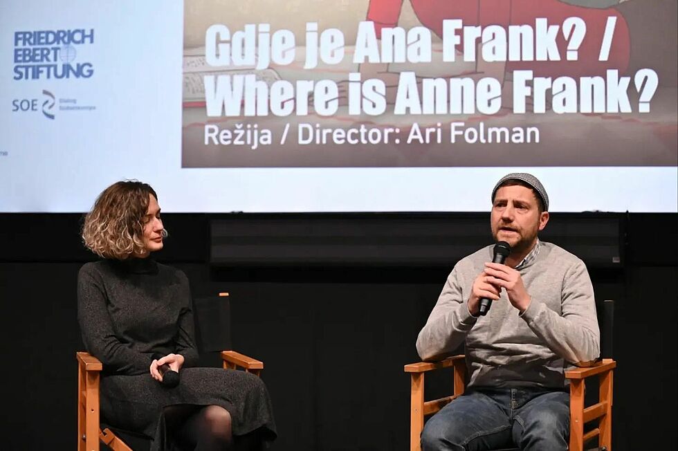 Panel discussion after film screening. Behind the speakers, film screen shows announcement for film "Where is Ana Frank?". The panel has two speakers Asja Krsmanović (L) and Igor Benacion Kožemjakin (R).